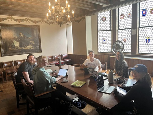 Students sitting around a table with laptops