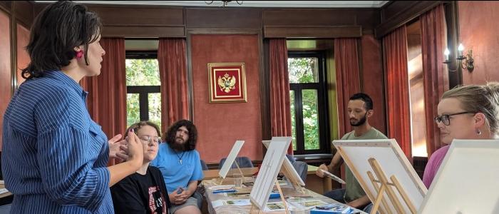 People sitting around a table with easels and canvases in front of them