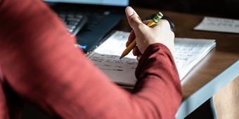Closeup of a student writing in a notebook.