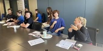 People sitting around a conference table eating and talking